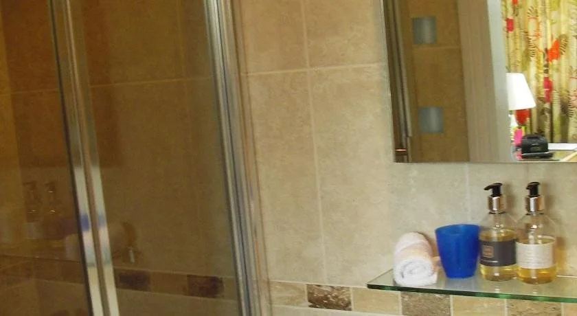 En suite bathroom with glass shelf and toiletries