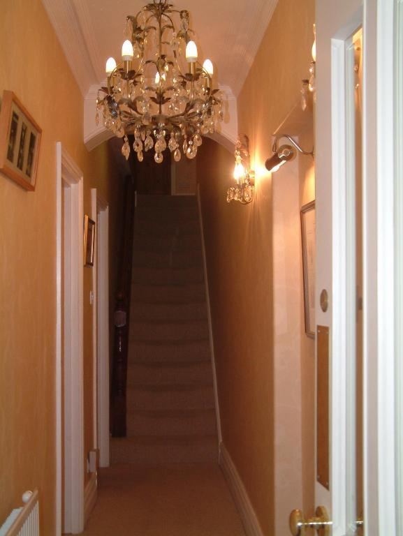 Hallway with staircase and chandelier