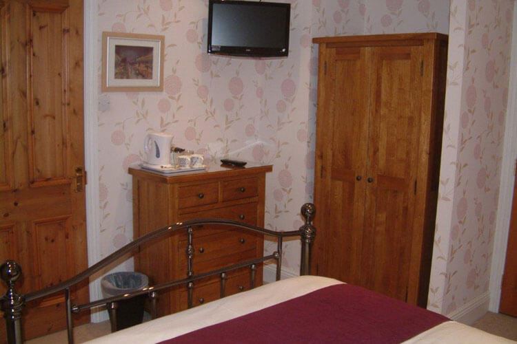 Same double room: wardrobe corner with wall-mounted TV and tea tray