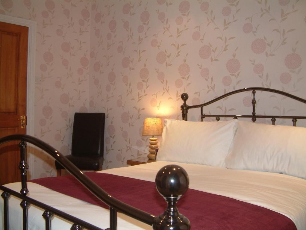 Double guest room with brass bed, dotted wallpaper and wooden wardrobe